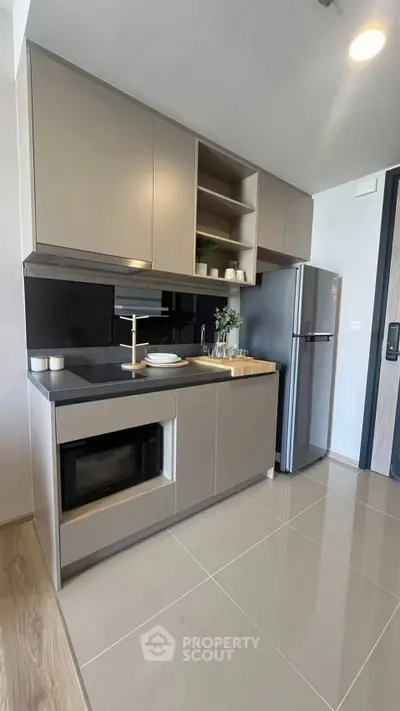 Modern kitchen with sleek cabinetry and stainless steel appliances in a stylish apartment.