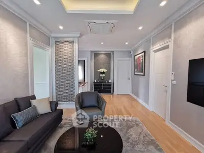Elegant living room with modern decor, featuring a cozy sofa, stylish armchair, and chic wall accents.