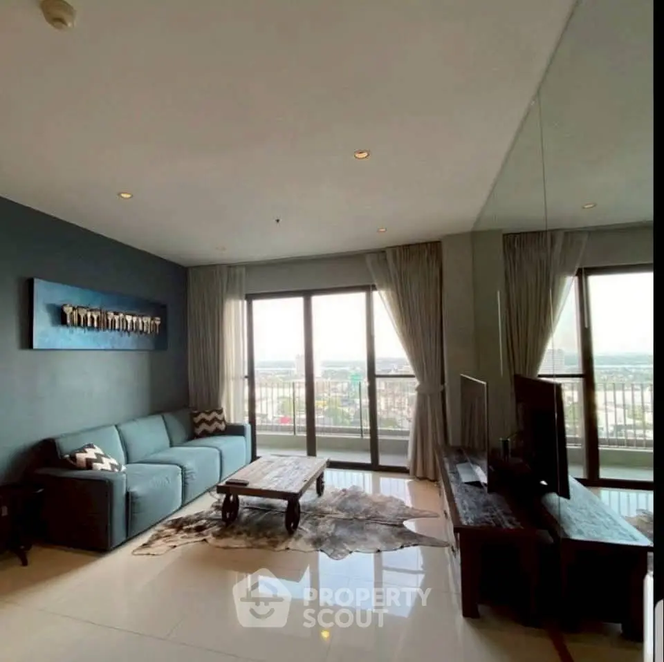 Spacious living room with modern decor and stunning city view from large windows.