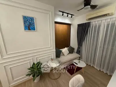 Cozy living room with modern decor, featuring a comfortable sofa, stylish wall art, and elegant lighting.