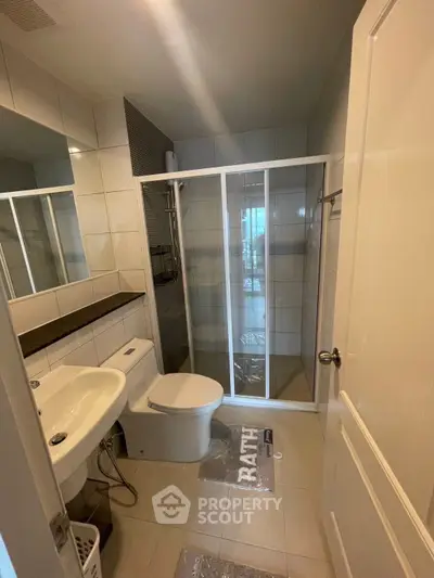 Modern bathroom with glass shower and sleek fixtures in a contemporary apartment.