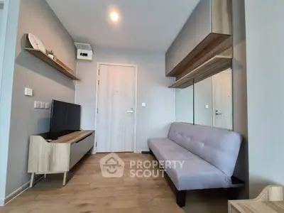 Modern living room with sleek furniture and wooden flooring, featuring a wall-mounted TV and stylish shelving.