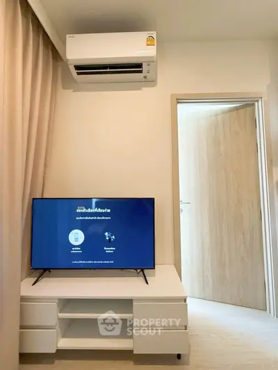 Modern living room with air conditioning and sleek TV setup in a cozy apartment.