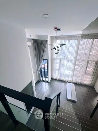 Modern duplex living room with high ceilings and large windows