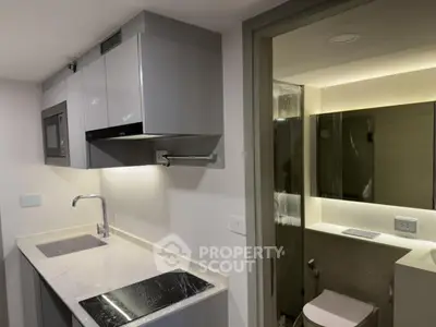 Modern compact kitchen with sleek cabinetry and adjacent bathroom