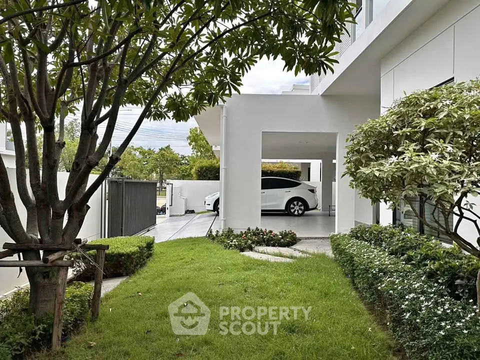 Modern home exterior with lush garden and carport