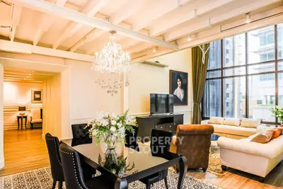 Luxurious living room with elegant chandelier and large windows offering city views.