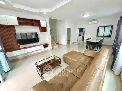 Spacious modern living room with leather sofa and open dining area