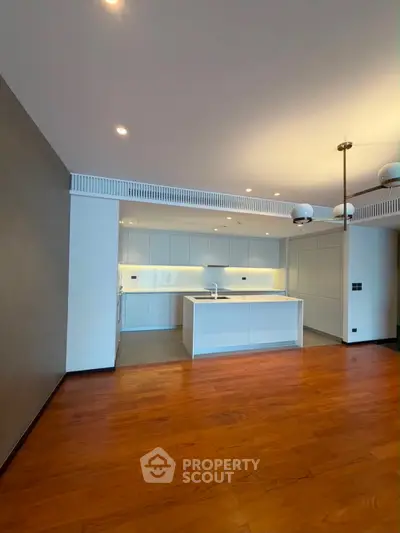 Spacious modern kitchen with sleek white cabinetry and open layout in luxury apartment.