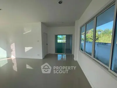 Spacious modern living room with large windows and glossy tiled floors