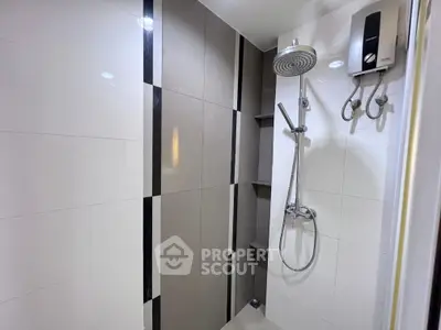 Modern bathroom with sleek shower and water heater, featuring stylish tile design.