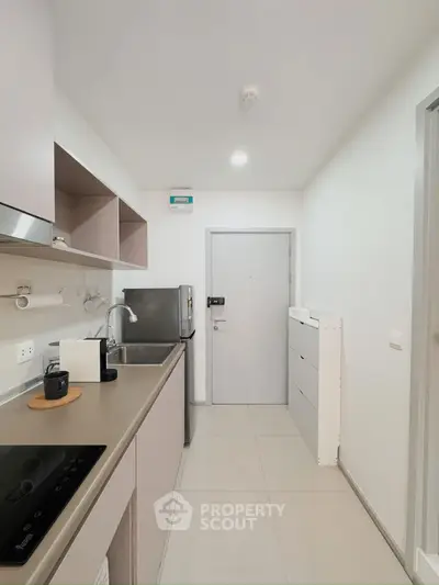 Modern kitchen with sleek cabinetry and stainless steel appliances in a compact layout.