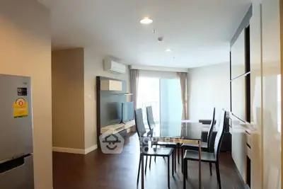 Modern dining area with sleek glass table and stylish chairs in a bright apartment.