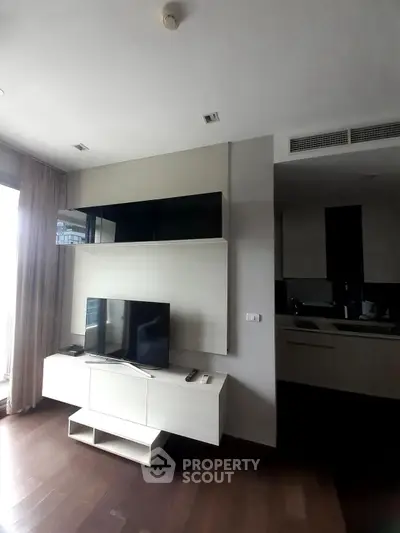 Modern living room with sleek TV stand and open kitchen layout