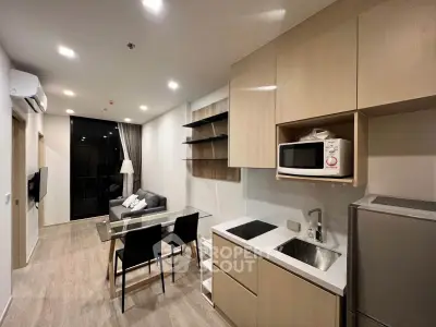 Modern open-layout living room and kitchen with sleek cabinetry and contemporary furnishings.