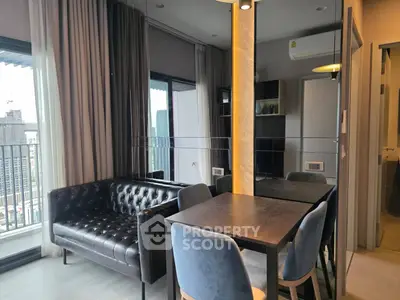 Modern living room with stylish furniture and city view balcony in a high-rise apartment.