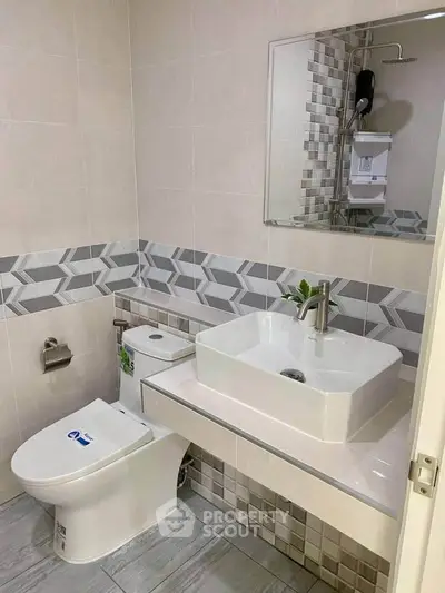 Modern bathroom with stylish sink and geometric tile accents