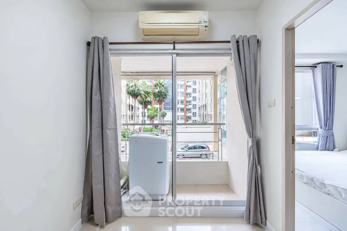 Modern apartment with balcony and washing machine, featuring sleek interior design and natural light.