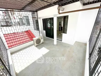Spacious balcony with secure metal grating and air conditioning unit, perfect for relaxation.