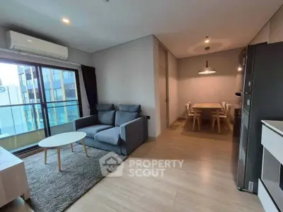 Modern living room with dining area and balcony view in a stylish apartment.