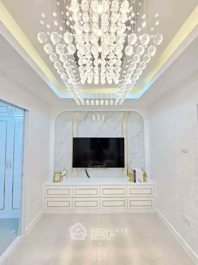 Luxurious living room with elegant chandelier and modern TV setup