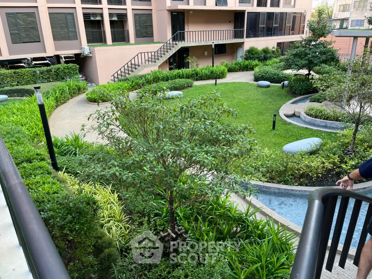 Lush garden view in modern residential complex with landscaped pathways and greenery.