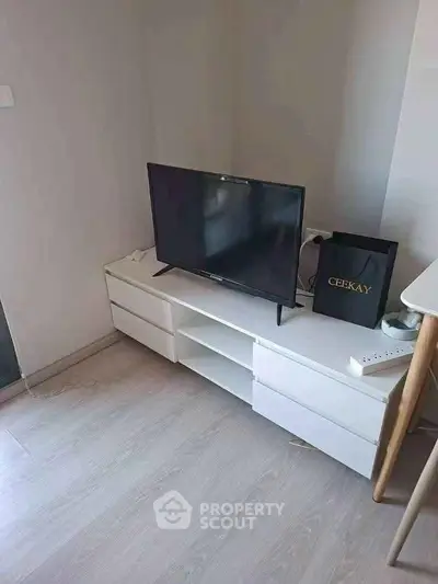 Modern living room corner with sleek TV stand and flat-screen TV, perfect for cozy entertainment setup.