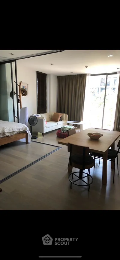Spacious open-plan living room with dining area and large windows