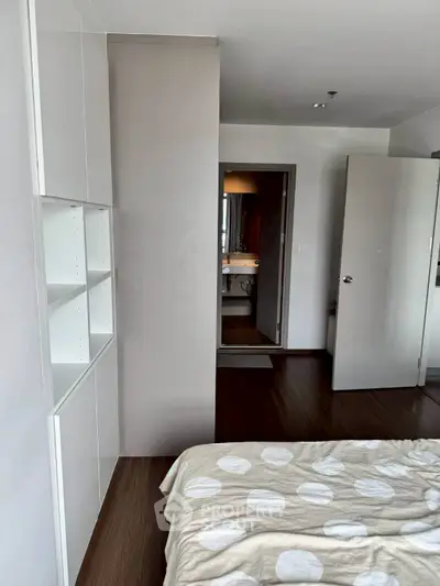Modern bedroom with open view to bathroom, featuring sleek design and neutral tones.