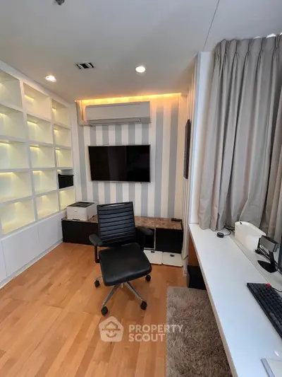 Modern study room with sleek design, featuring built-in shelves, a flat-screen TV, and stylish office chair.