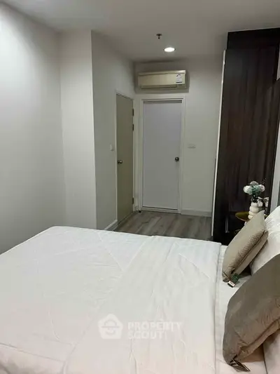 Cozy bedroom with modern decor and air conditioning in a stylish apartment.