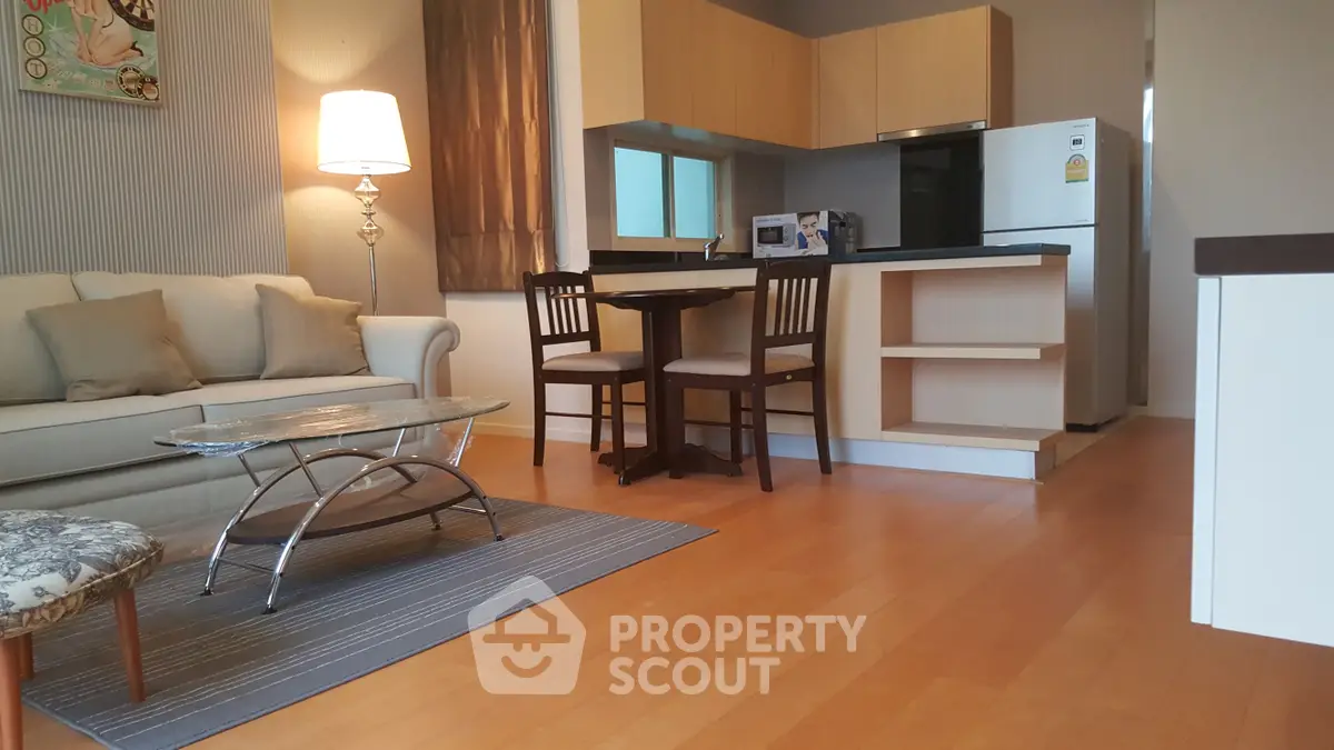 Modern open-layout living room with cozy seating and stylish kitchen area.