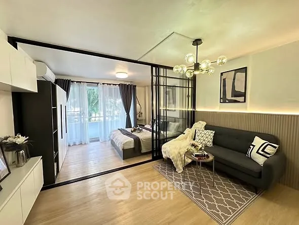 Modern studio apartment with stylish decor and glass partition separating bedroom and living area.