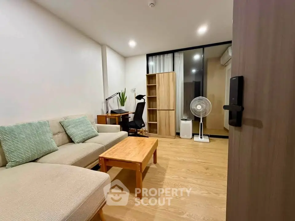 Modern living room with cozy sofa, wooden furniture, and study area in a stylish apartment.