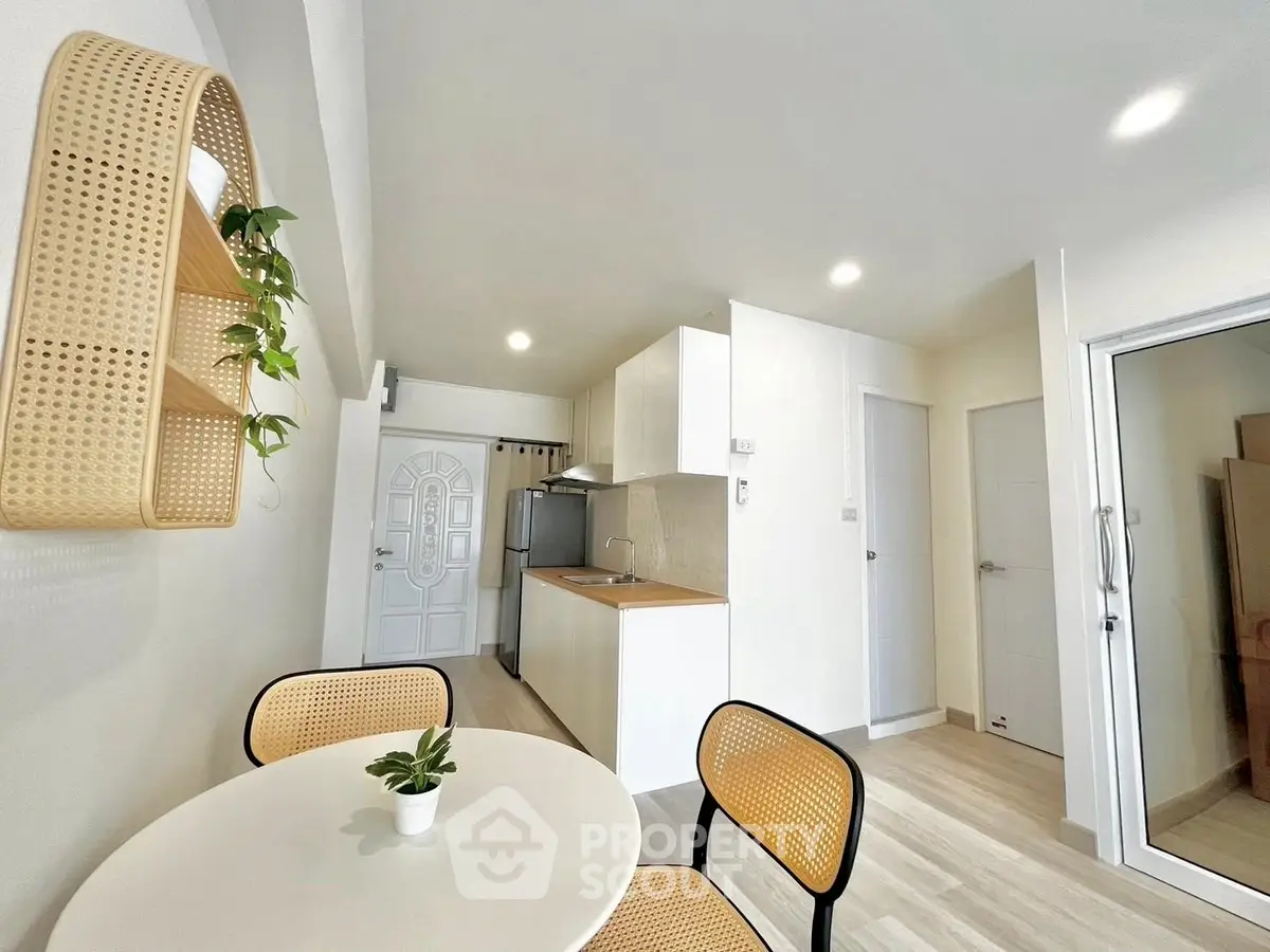 Modern kitchen with dining area, featuring sleek cabinetry and stylish decor.