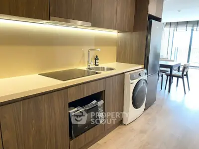 Modern kitchen with sleek wooden cabinets and built-in appliances in a stylish apartment.
