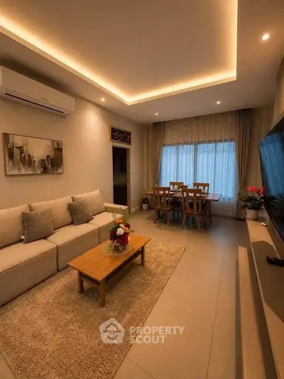 Elegant living room with modern decor and cozy dining area, featuring ambient lighting and stylish furnishings.