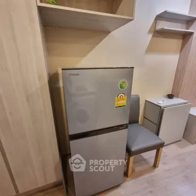 Modern kitchen with sleek fridge and stylish shelving in cozy apartment