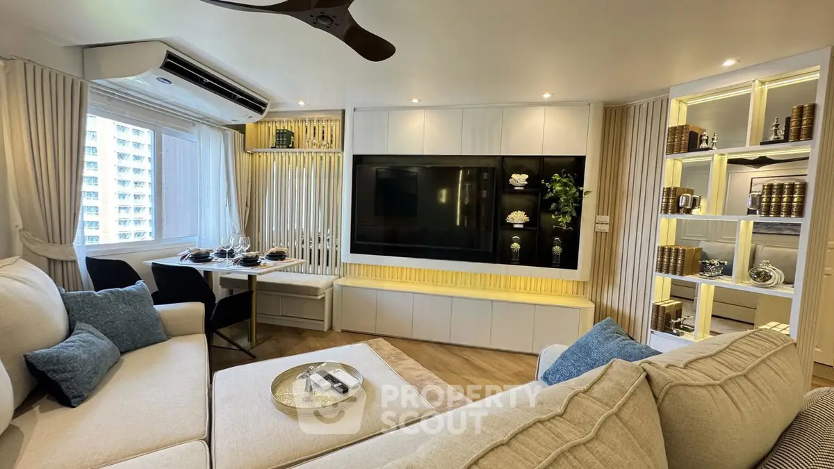 Luxurious modern living room with elegant decor and large TV, perfect for relaxation and entertainment.