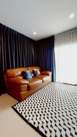 Modern living room with leather sofa and stylish geometric rug