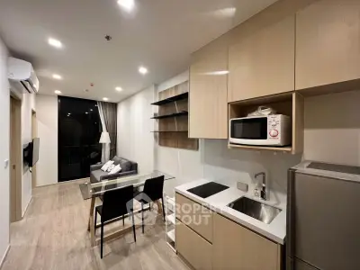 Modern open-layout kitchen and living room with sleek cabinetry and stylish furnishings.