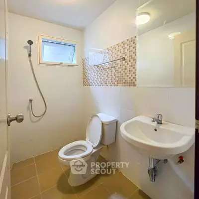 Modern bathroom with shower, toilet, and sink in a compact layout.