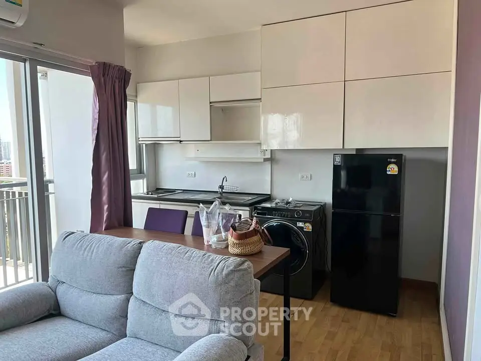 Modern compact kitchen with washing machine and fridge in cozy apartment