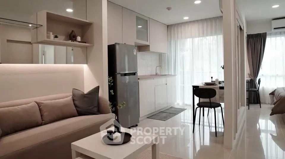 Modern open-plan living room and kitchen with sleek design and natural light.