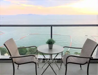 Stunning ocean view from a modern balcony with cozy seating arrangement.