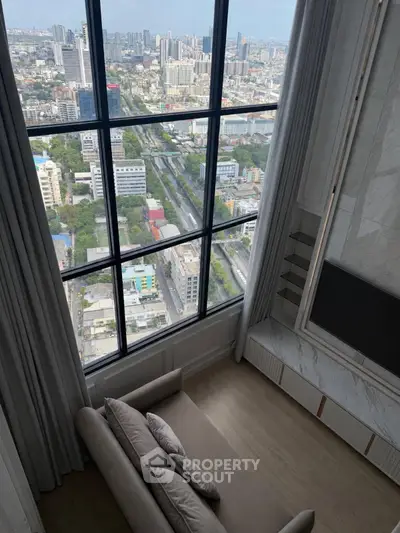 Luxurious high-rise living room with stunning city view through large windows.