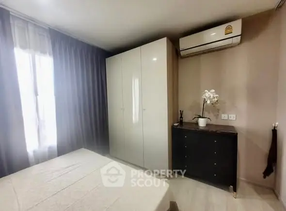 Cozy bedroom with modern wardrobe and air conditioning in a stylish apartment.