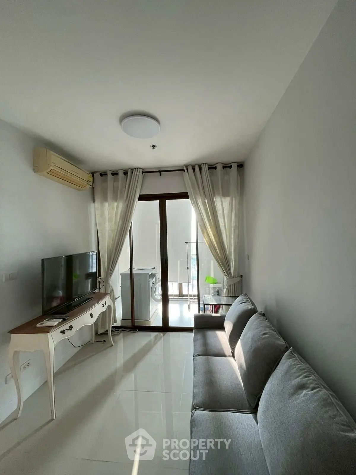 Bright living room with modern furniture and balcony access, perfect for relaxation and entertainment.