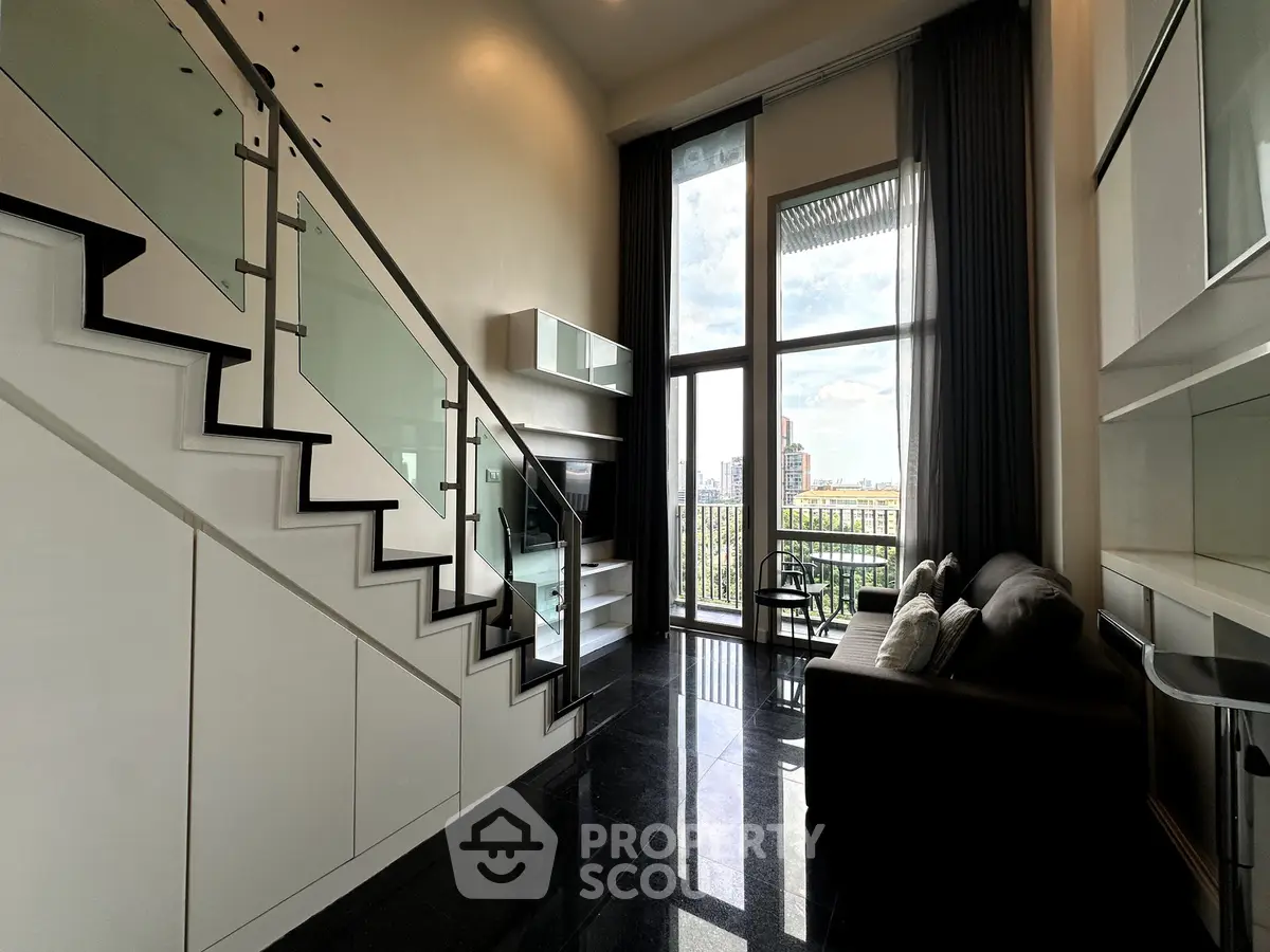 Modern duplex living room with high ceilings and city view balcony