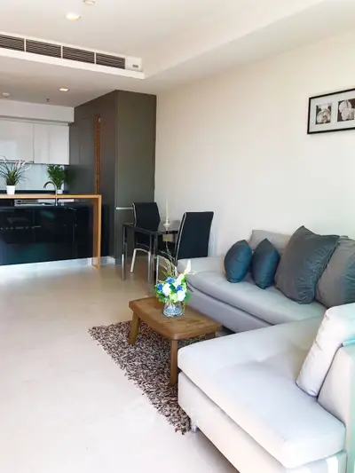 Modern living room with sleek kitchen, cozy sofa, and elegant decor in open layout apartment.